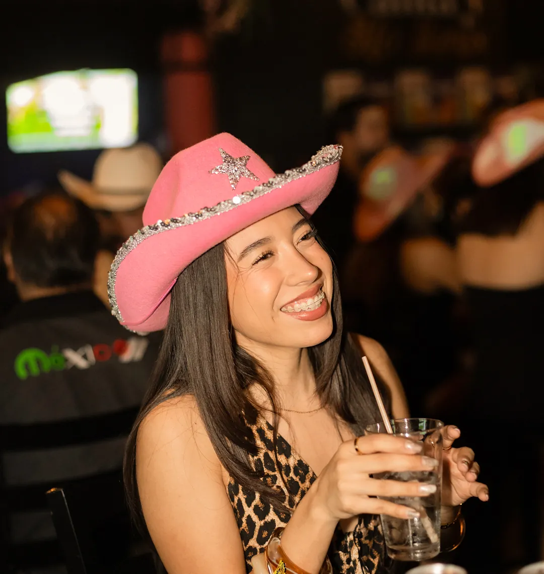 Asistente con sombrero rosa durante la noche